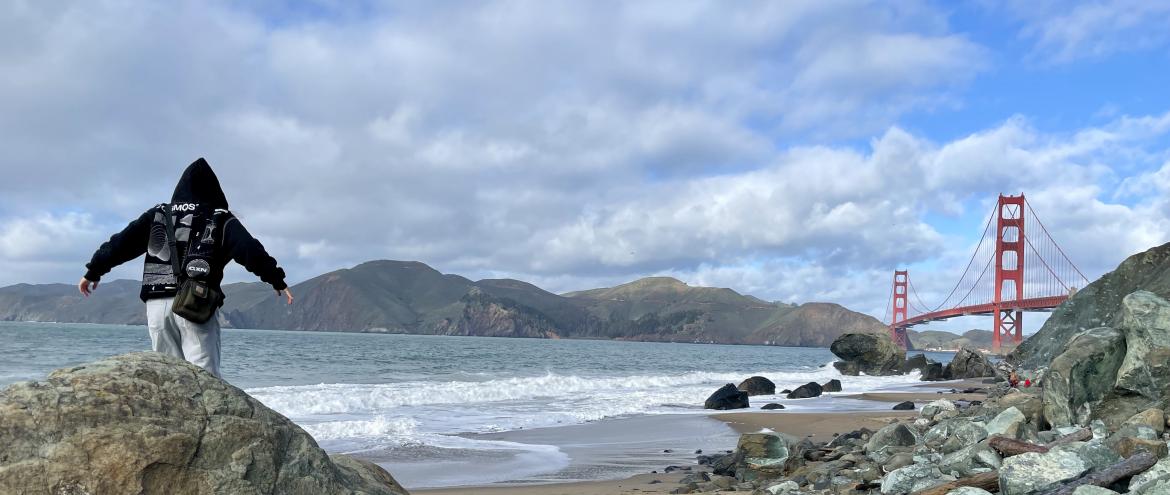 escaladant des rochers sur une plage à San Francisco près du Golden Gate Bridge 